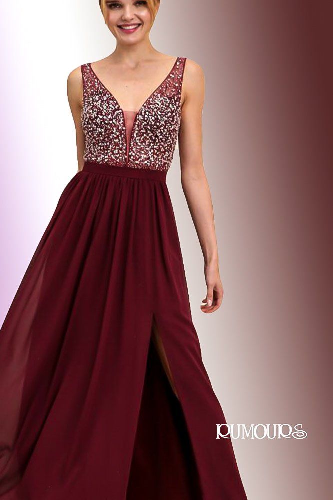Woman in burgundy sequined bodice gown with high slit, smiling.