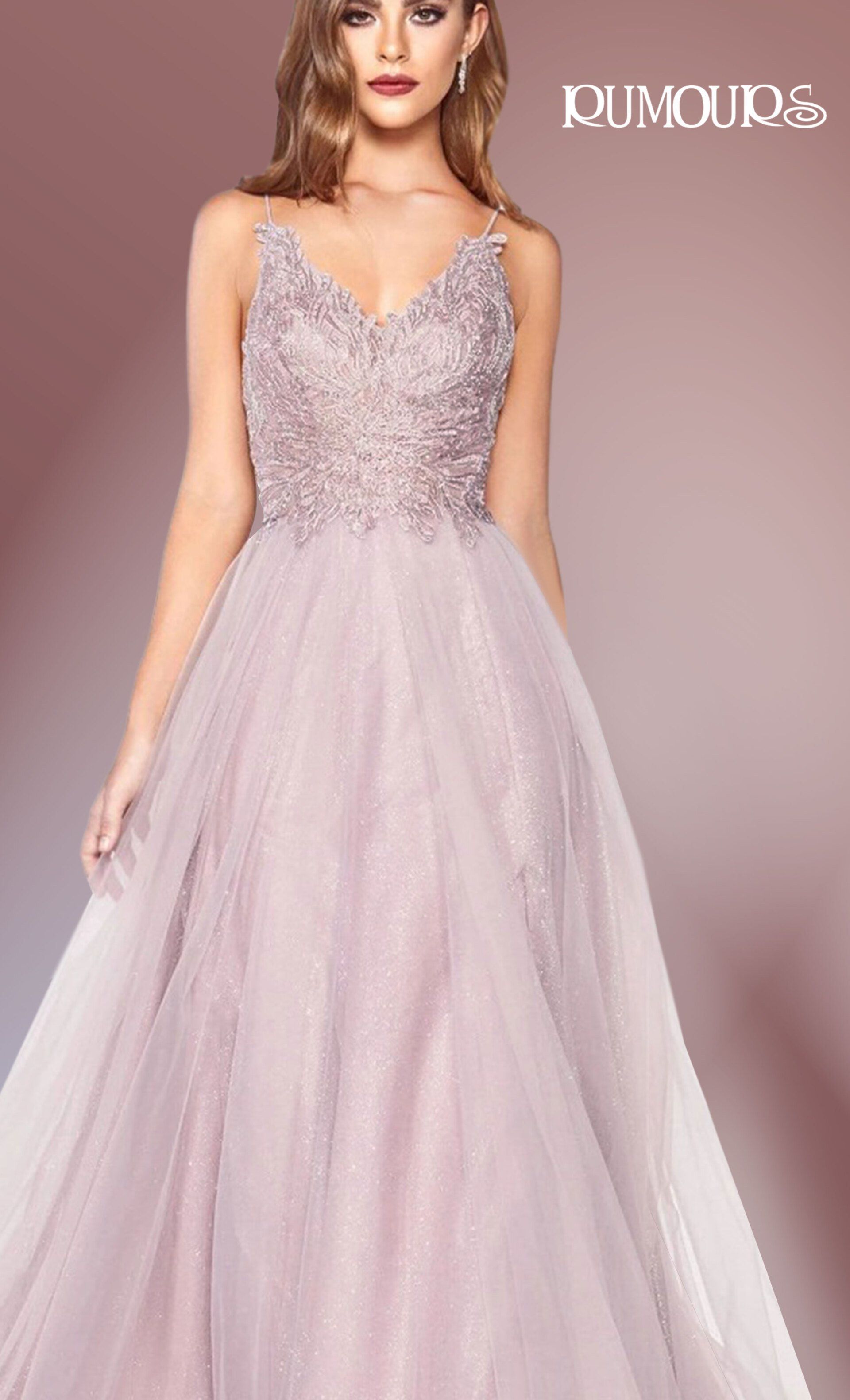 Woman in a sparkly pink formal gown, with embellished bodice and flowing skirt, standing indoors.