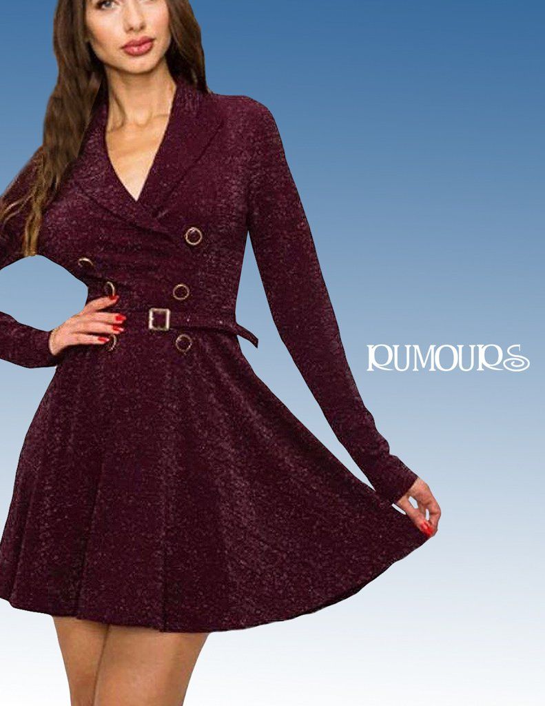 Woman in a burgundy sparkly dress with a belted waist, posing.