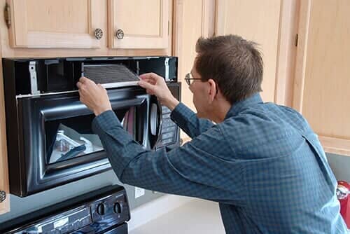 Technician Repairing the Fan over a Microwave and Oven - Appliance Services and Repair in Worth, IL Technician Repairing the Fan over a Microwave and Oven - Appliance Services and Repair in Worth, IL