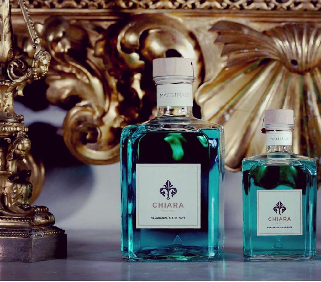 Due flaconi di profumo CHIARA color turchese su uno sfondo dorato decorato.