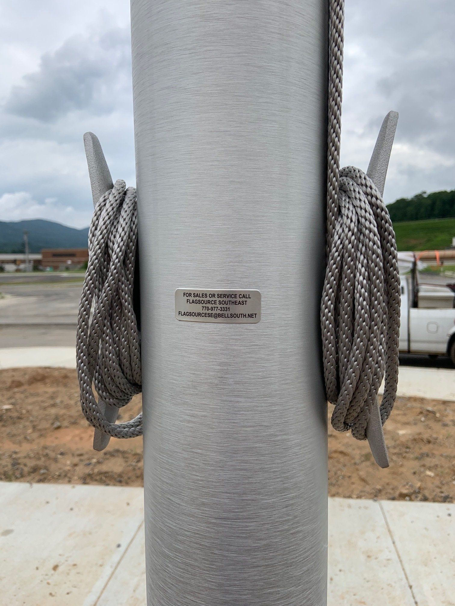 A flag pole with two ropes attached to it