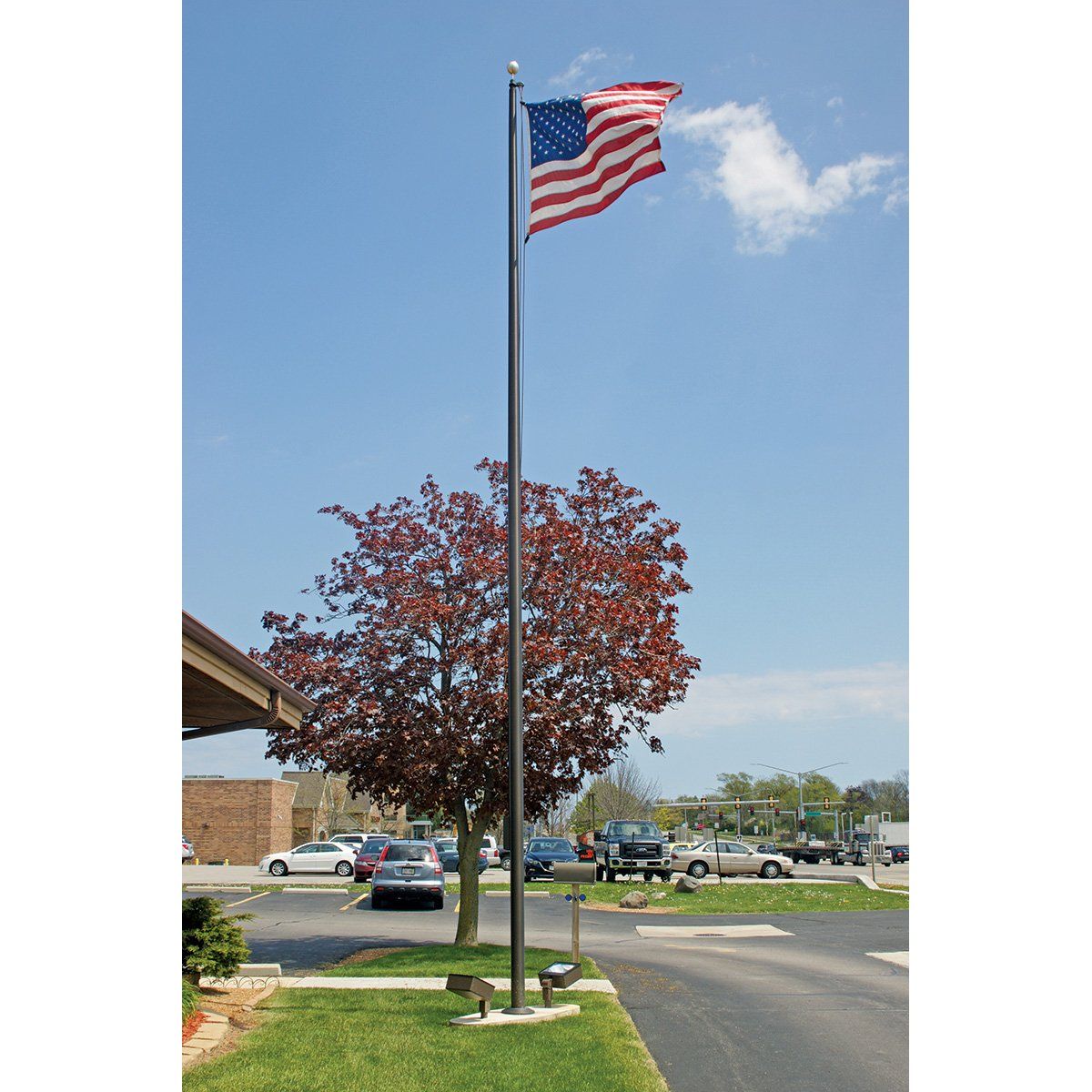 An american flag is flying in front of a parking lot