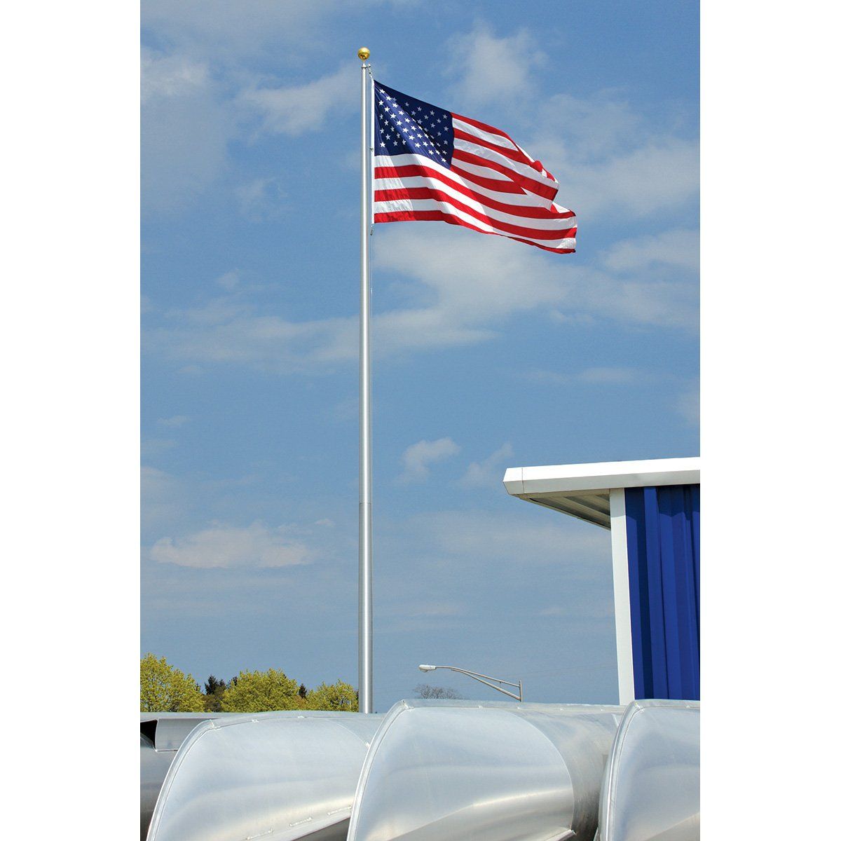 An american flag is flying in the wind in front of a building