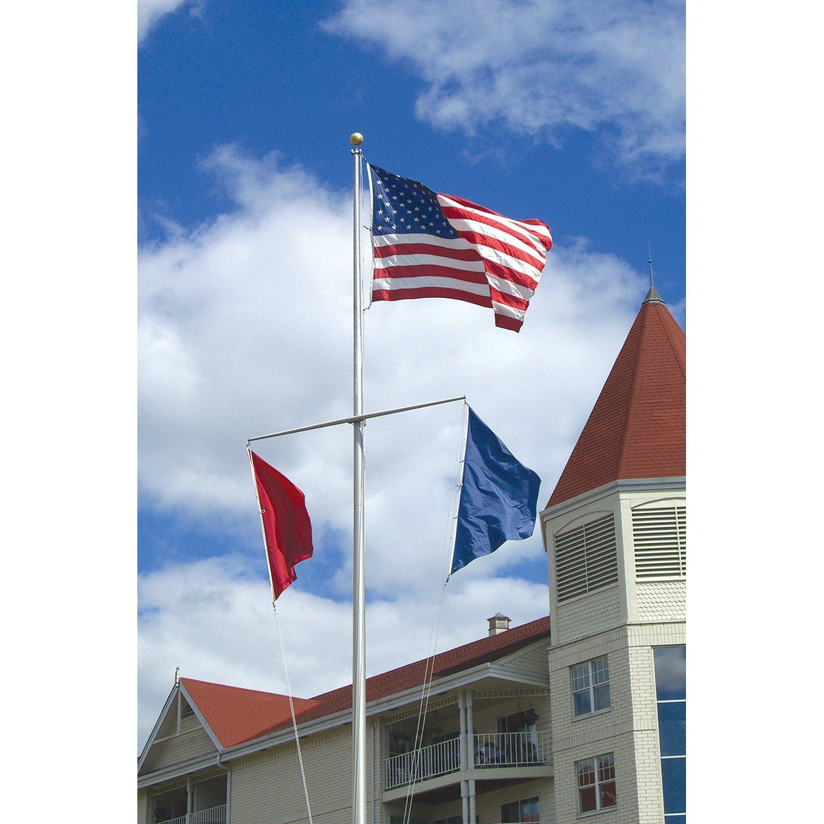 Three flags on a pole in front of a building