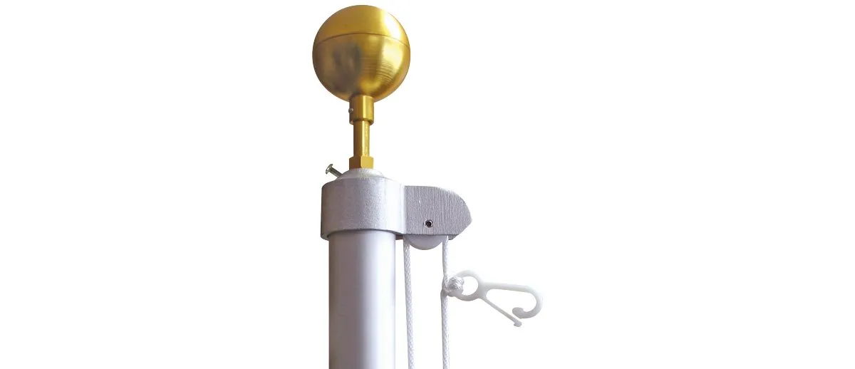 A white pole with a gold ball on top of it.