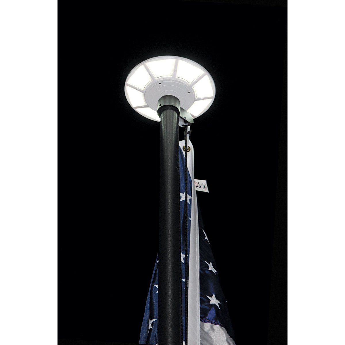 A flag pole with a light on top of it and an american flag hanging from it.