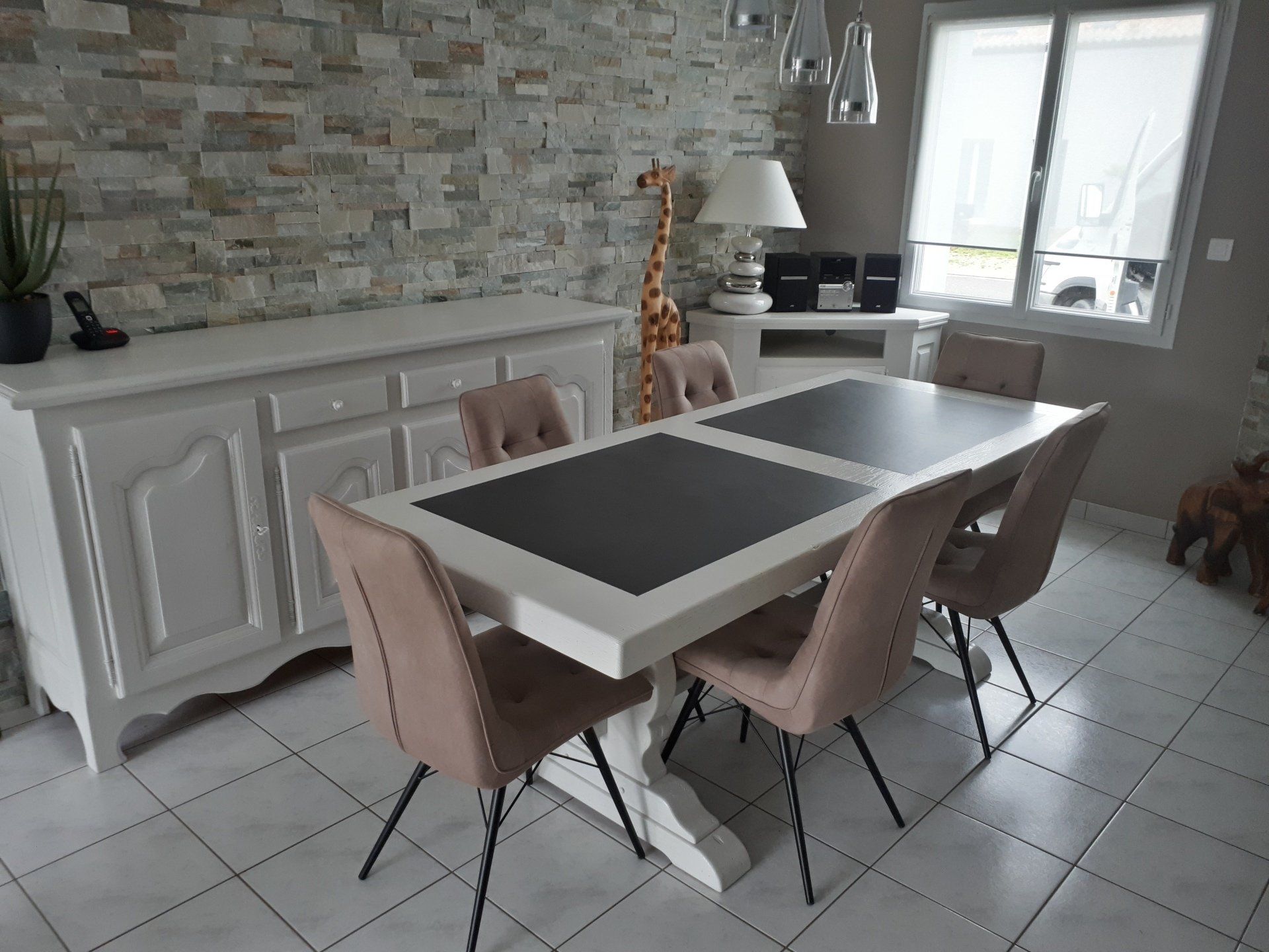 Une salle à manger avec une table et des chaises et une lampe girafe