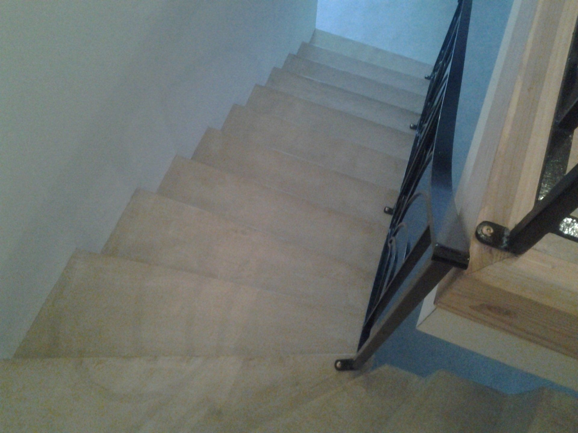 Un escalier avec une rampe en métal et une main courante en bois