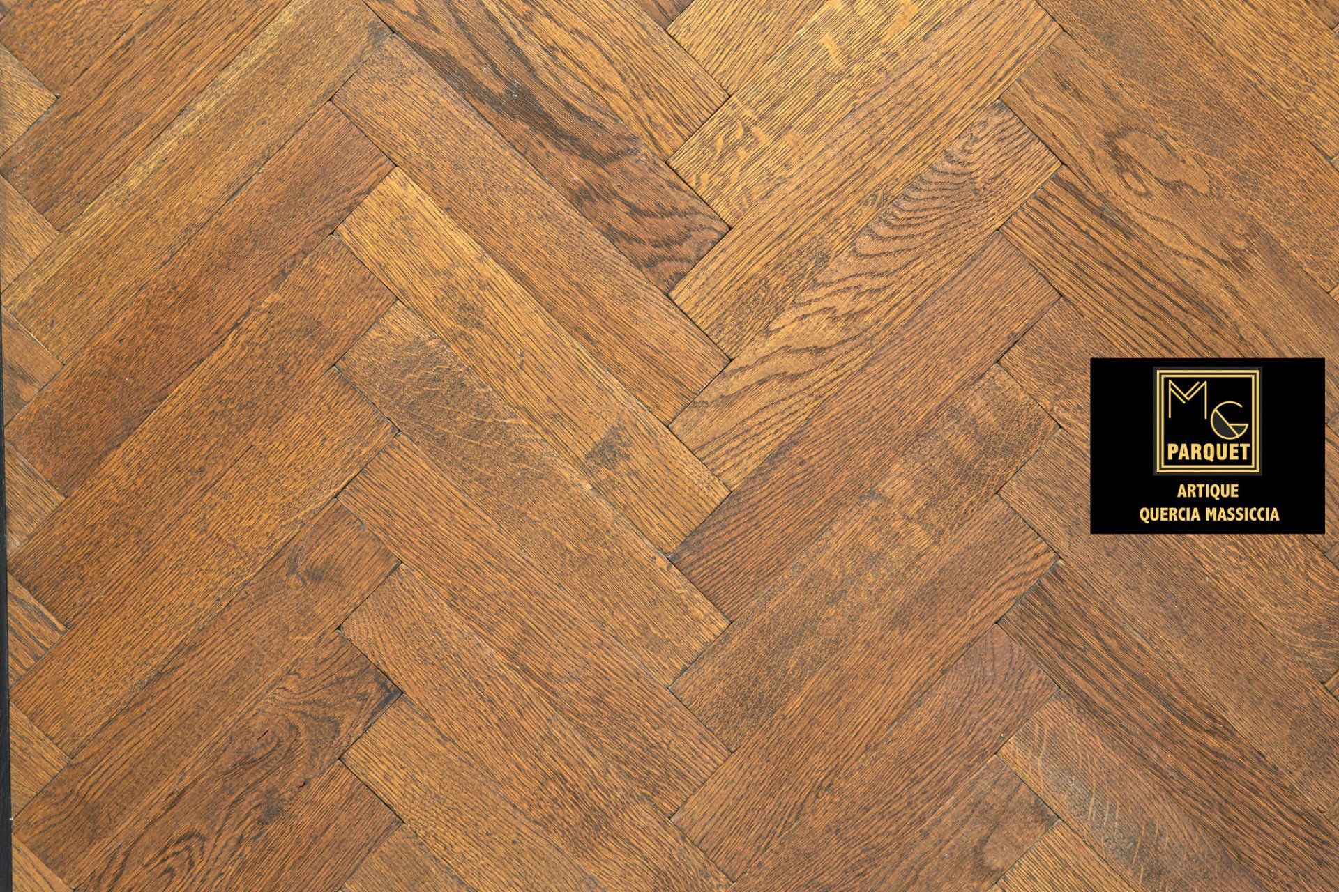 Pavimento in legno con motivo a spina di pesce nelle tonalità del marrone.