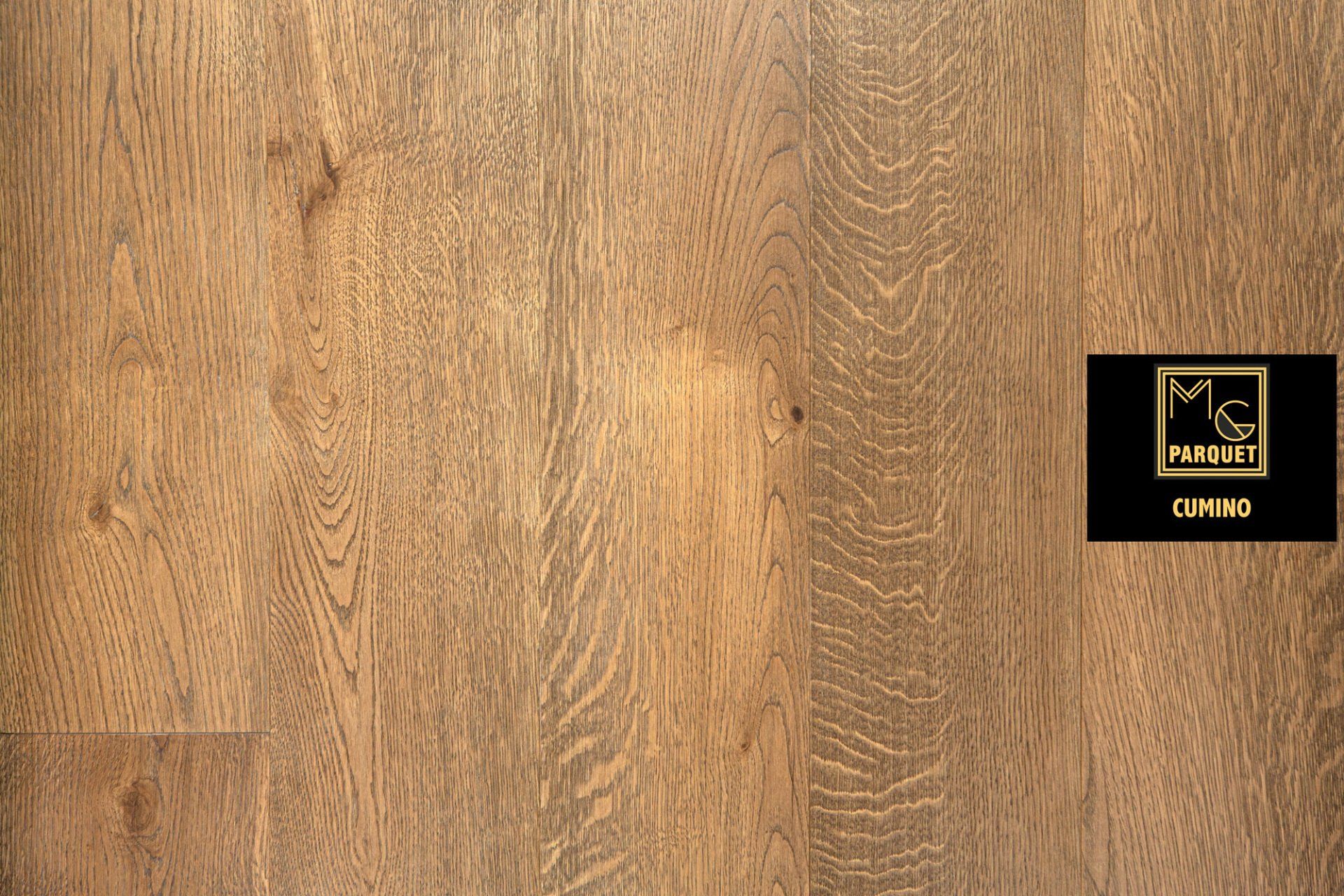 Primo piano di assi del pavimento in legno nelle tonalità del marrone chiaro e medio con un'etichetta del marchio.