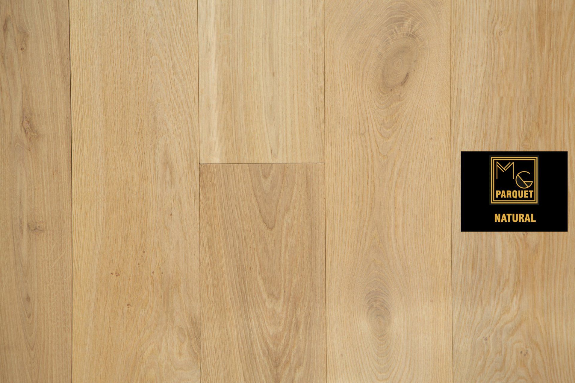 Pavimento in legno chiaro con venature visibili. Etichetta nera con scritta dorata