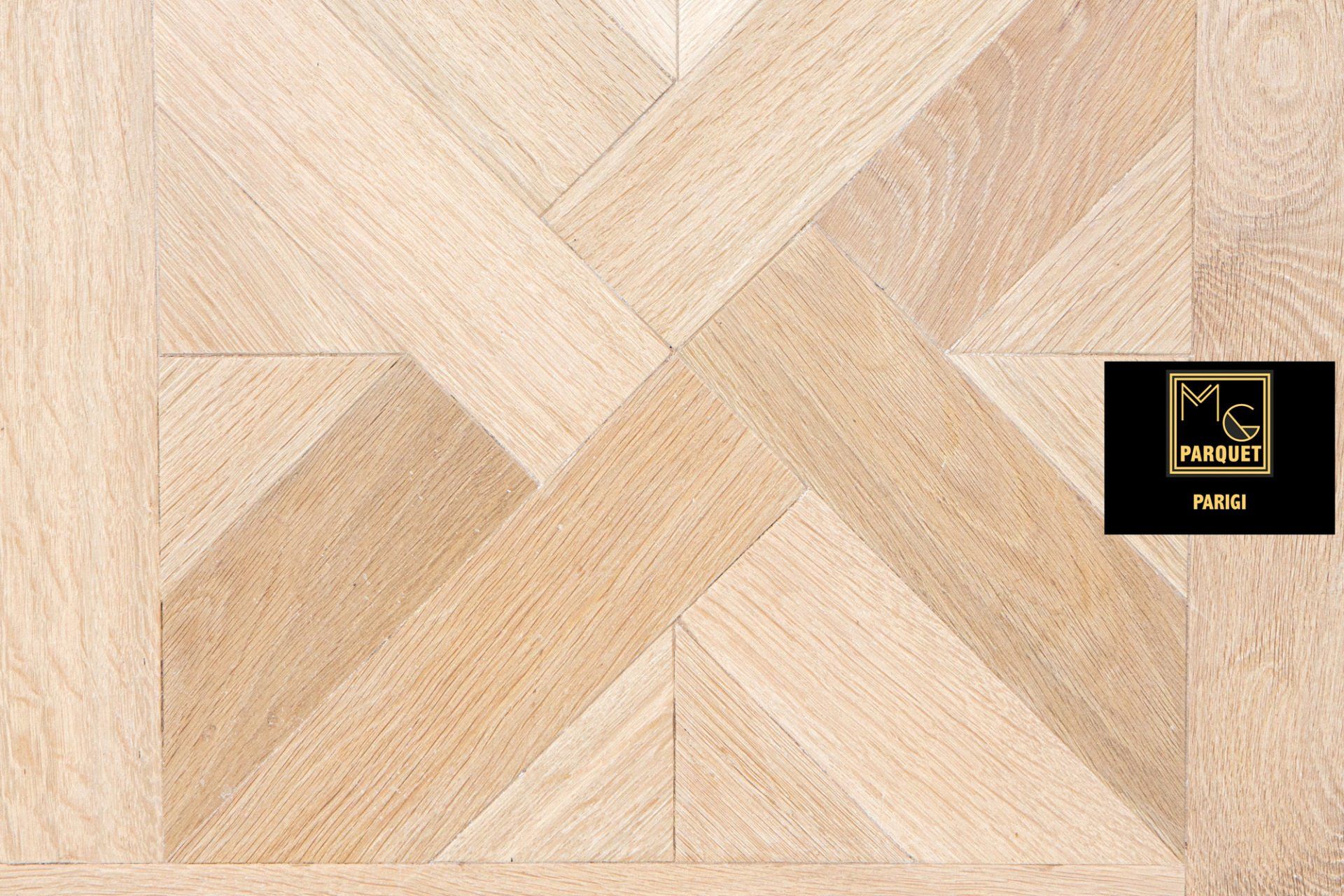 Pavimento in legno chiaro con motivo geometrico, caratterizzato da assi angolate ad incastro.