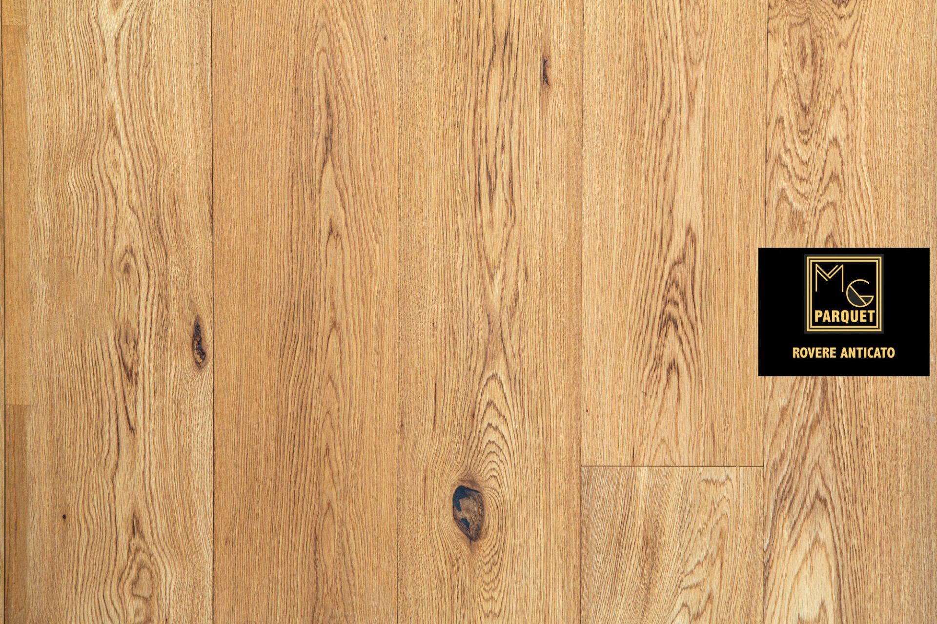 Pavimento in legno marrone chiaro con venature visibili e logo scuro.