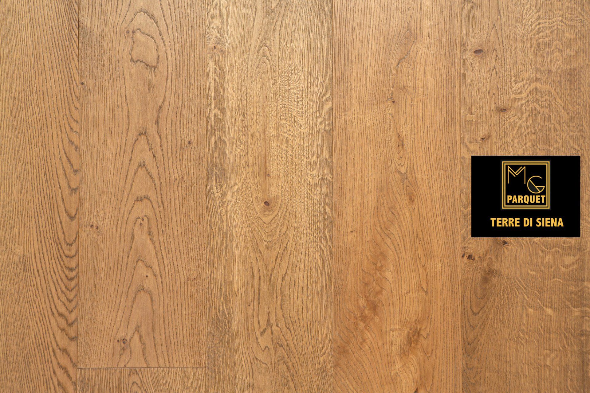 Pavimento in legno marrone chiaro con logo nero e oro sul lato destro.