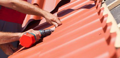 New Roof — Workers Installing Red Metal Tiles in Citrus County, FL New Roof — Workers Installing Red Metal Tiles in Citrus County, FL