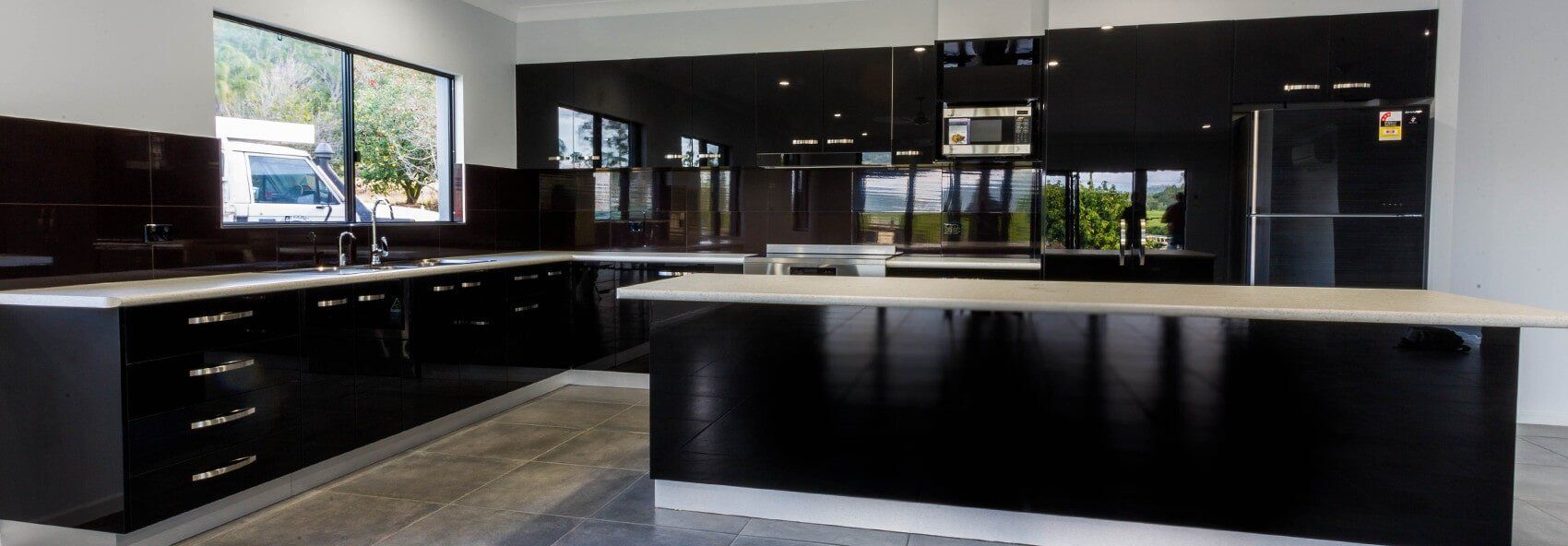 A kitchen with black cabinets and a large island