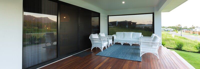 A wooden deck with a couch and chairs on it