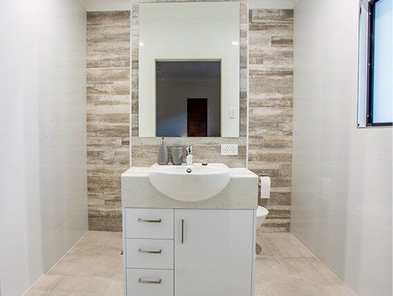 A bathroom with a sink , mirror and toilet.