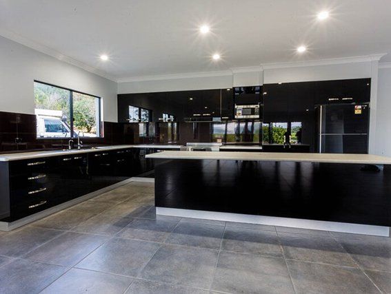 A kitchen with black cabinets and a large island
