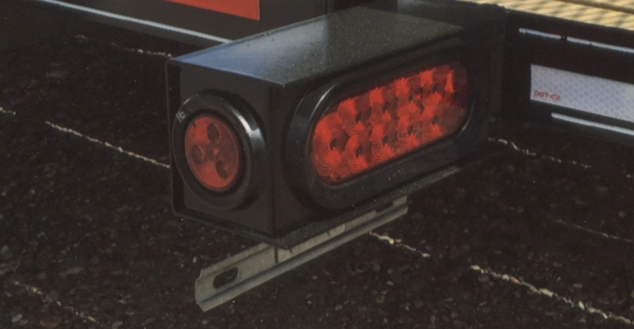 Red emergency light bar on a black surface with red lenses illuminated