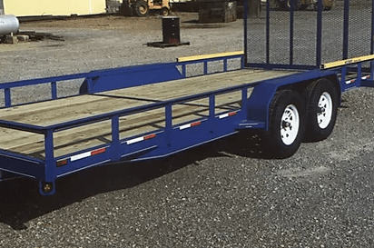 Blue dual-axle flatbed utility trailer on gravel, with metal side rails and white wheels