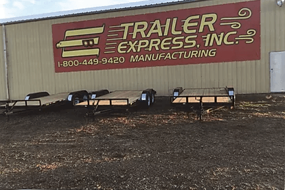 Trailer Express Inc. sign on a beige building with parked trailers in front.