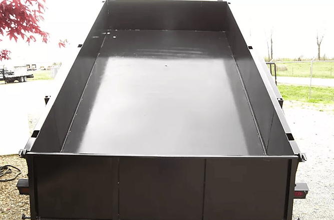 Black metal dump bed or trailer viewed from the rear outdoors