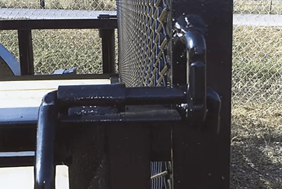 Black metal pipe and chain-link fence corner with outdoor railing in sunlight