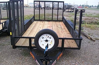 Small utility trailer with wooden deck, black mesh sides, and a spare tire at the front.