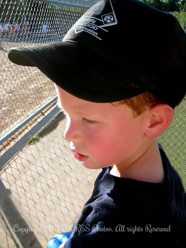 A young boy wearing a black hat and a blue shirt