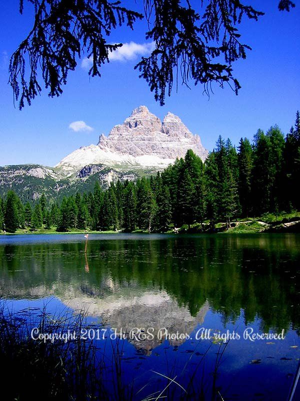 A lake surrounded by trees with a mountain in the background