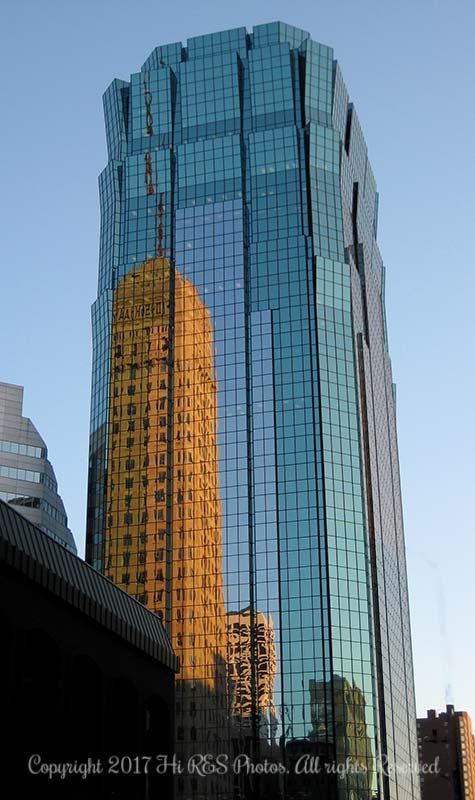 A tall building with a lot of windows and a blue sky in the background