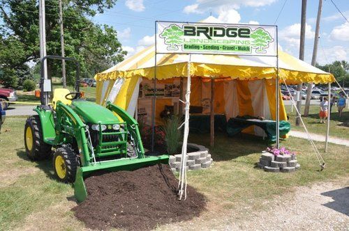 Green Tractor Beside A Tent — Sharpsville, IN — Bridge Landscaping Green Tractor Beside A Tent — Sharpsville, IN — Bridge Landscaping
