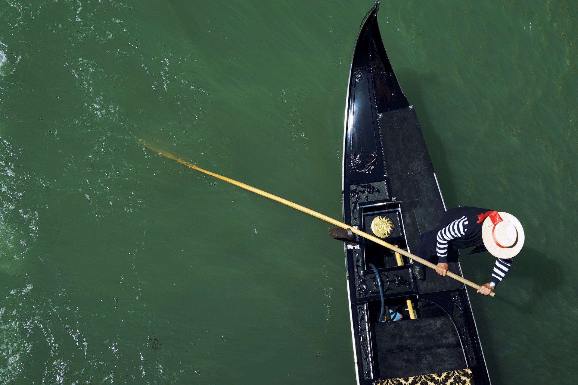 A man in a hat is rowing a boat in the water