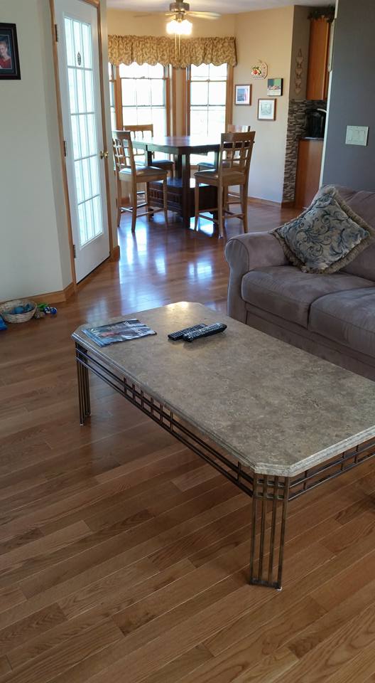 A living room with a couch , table , chairs and a coffee table.
