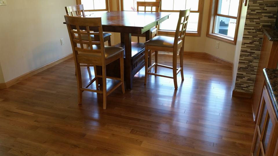 A dining room with hardwood floors and a table and chairs