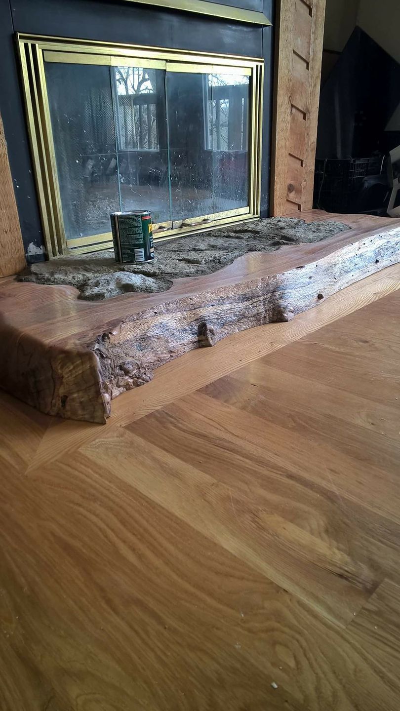 A fireplace with a wooden floor in a living room.