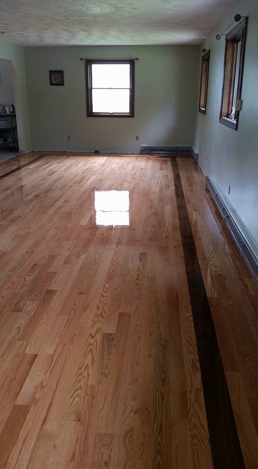 A large room with a wooden floor and a window.