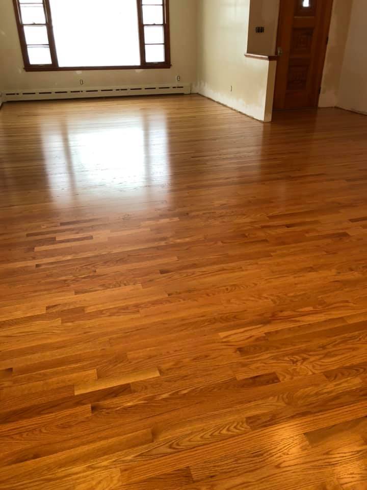 A living room with hardwood floors and a window.