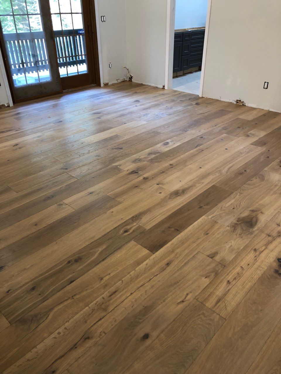 A living room with hardwood floors and sliding glass doors.