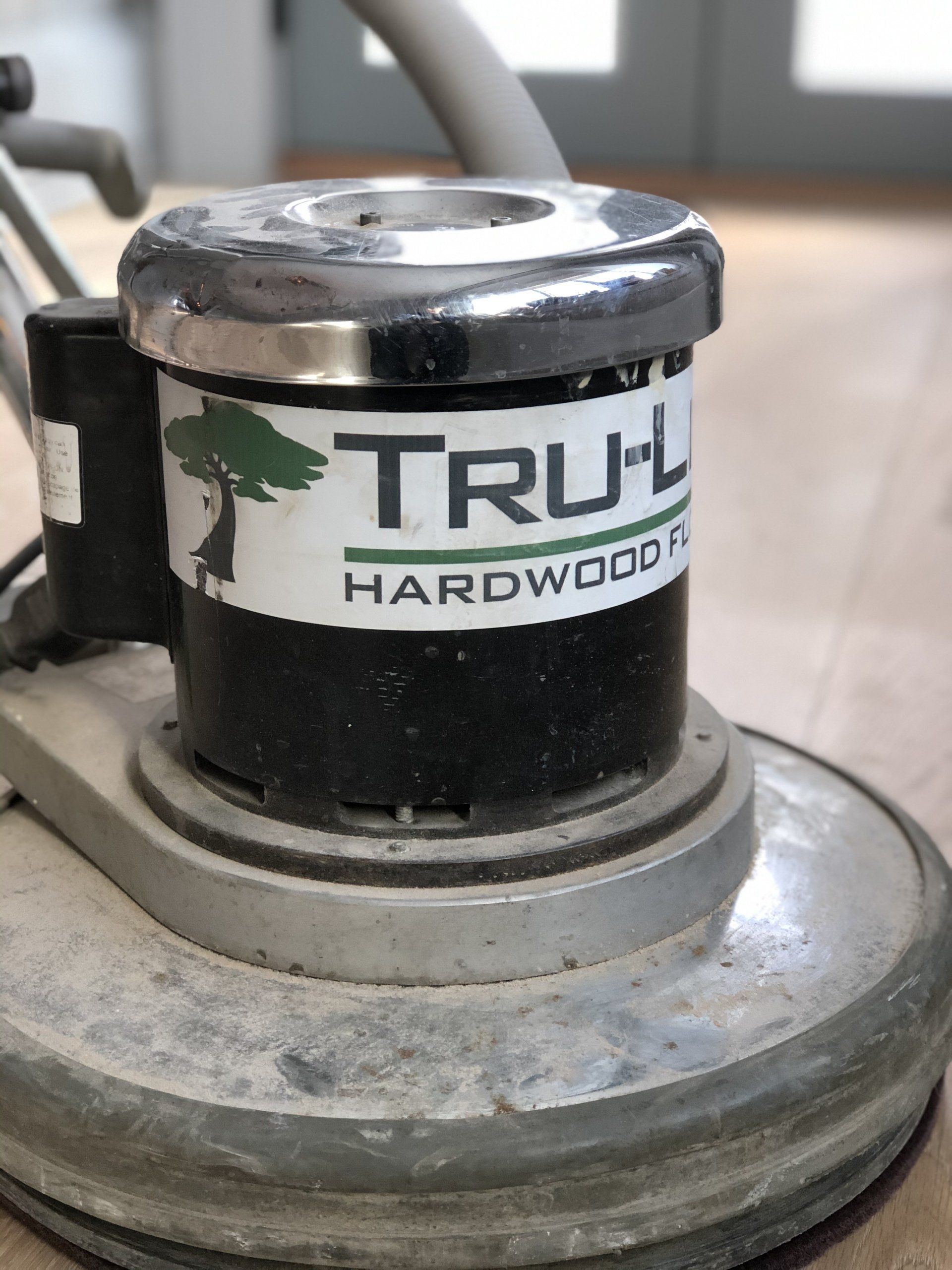 A tru-l hardwood floor polisher is sitting on a wooden floor