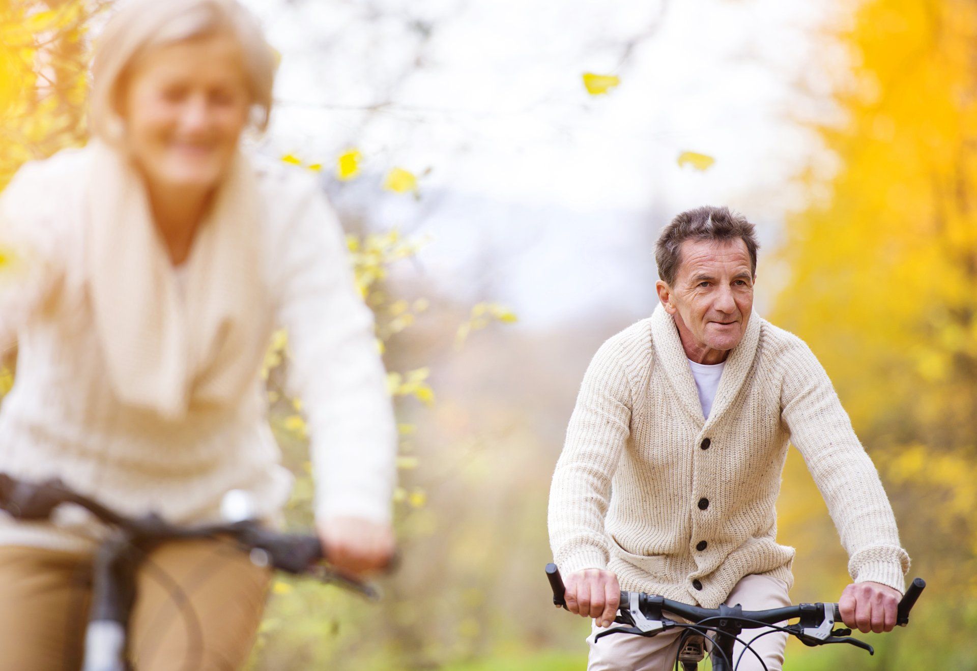 Ein Mann und eine Frau fahren in einem Park Fahrrad.