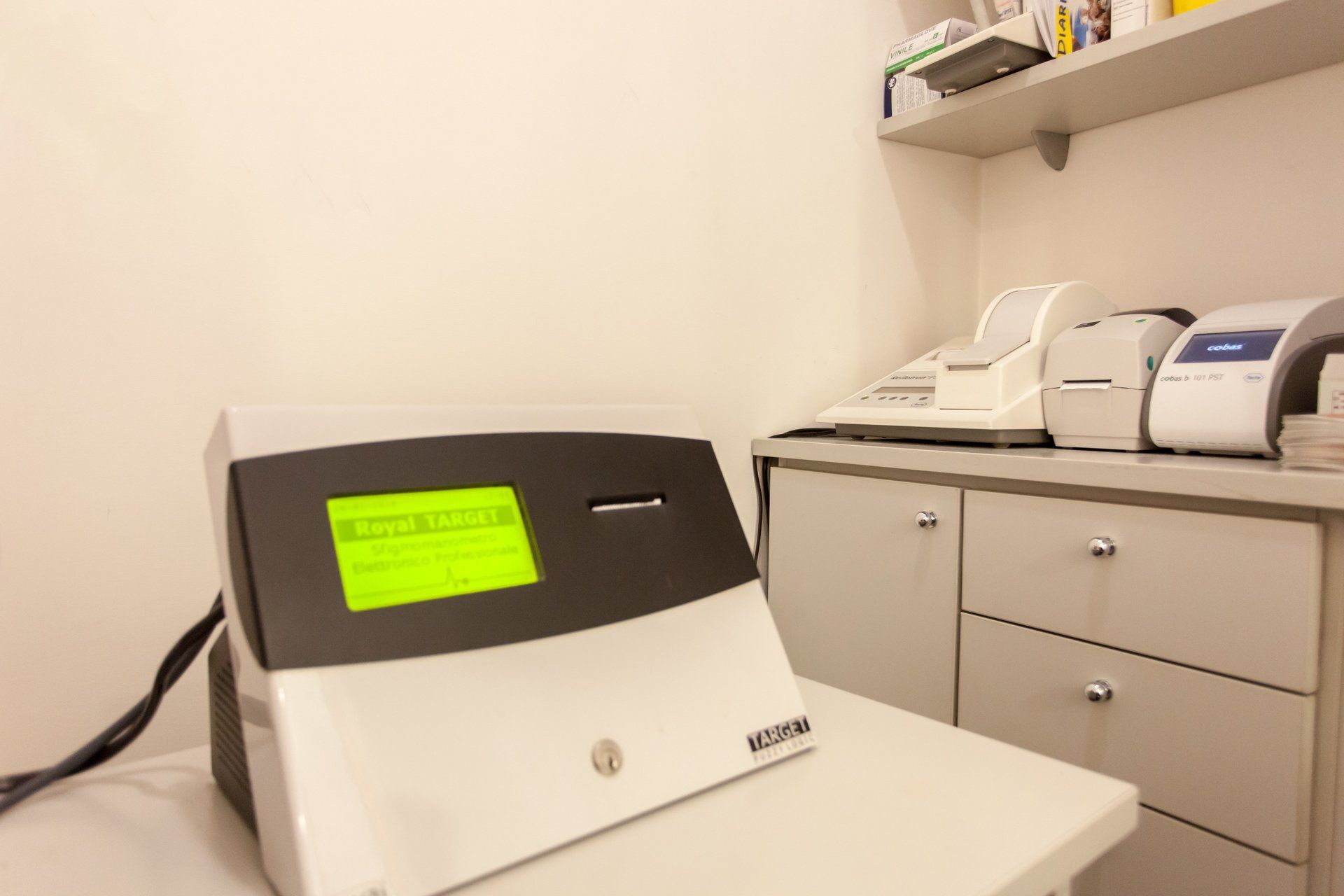 In un ufficio, un dispositivo elettronico da tavolo con uno schermo verde brillante è appoggiato su un tavolo bianco.