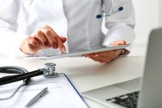 Medical Negligence — Doctor Checking His Tablet in Jackson, MS Medical Negligence — Doctor Checking His Tablet in Jackson, MS
