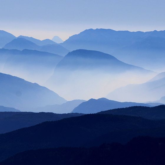 The mountains are covered in fog and the sky is blue