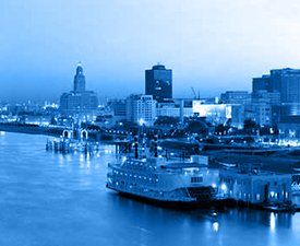 A boat is docked in a harbor with a city in the background.