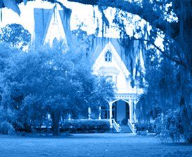 A blue and white photo of a house surrounded by trees