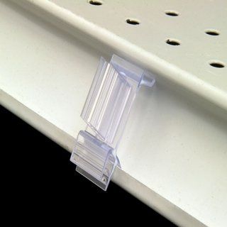 Señalizador de estante de plástico transparente fijado a un estante minorista blanco.