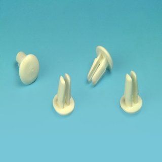 Cuatro pequeños tornillos de plástico de color blanco sobre una superficie azul.